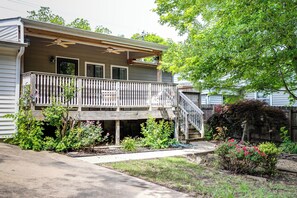 A two-story house with a balcony, a wooden deck, and a garden with various plants and flowers. - Newly renovated 3/2 in the middle of town (Jonesboro)