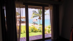 Una habitación con un amplio ventanal corredero que da a vista de la playa.