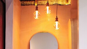 A bathroom with a round mirror, a wooden vanity, a towel rack, and a sink. - GlampCalar (Bacalar)