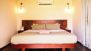 A hotel room with a wooden bed, a wall-mounted air conditioner, and a sign indicating WiFi availability. - GlampCalar (Bacalar)