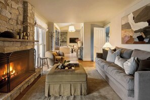 A cozy living room with a stone fireplace, a grey sofa, and a wooden coffee table. - 'Wychwood'- English Garden Estate with Pool (Upper Kangaroo River)