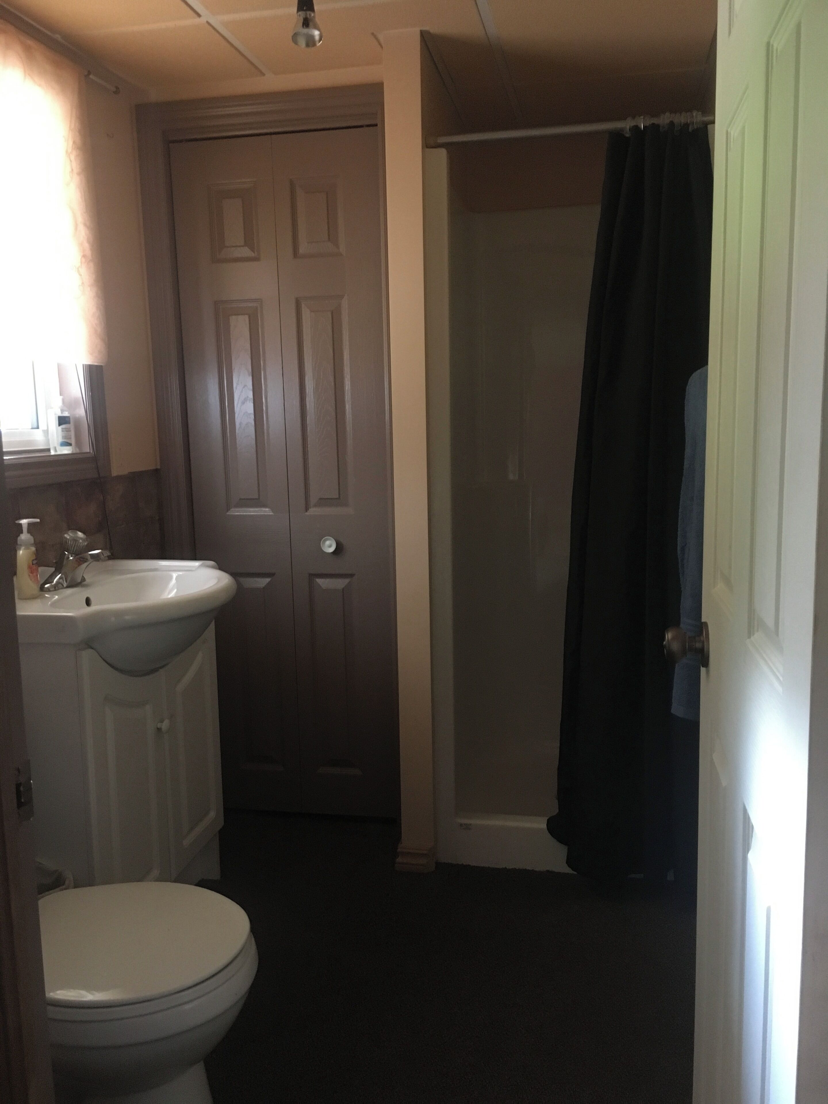 Une salle de bain comprenant des toilettes, un lavabo et un espace douche.