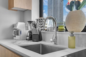 Eine moderne Küche mit eingebautem Spülbecken, Kaffeemaschine und Messerblock.