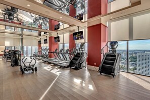 A gym with treadmills, weight machines, and a city view. - Luxury 2BR | Downtown Miami Near Worldcenter (Miami)