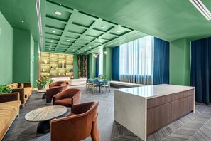 A modern lobby with a reception desk, seating area, and a decorative bookshelf. - Luxury 2BR | Downtown Miami Near Worldcenter (Miami)