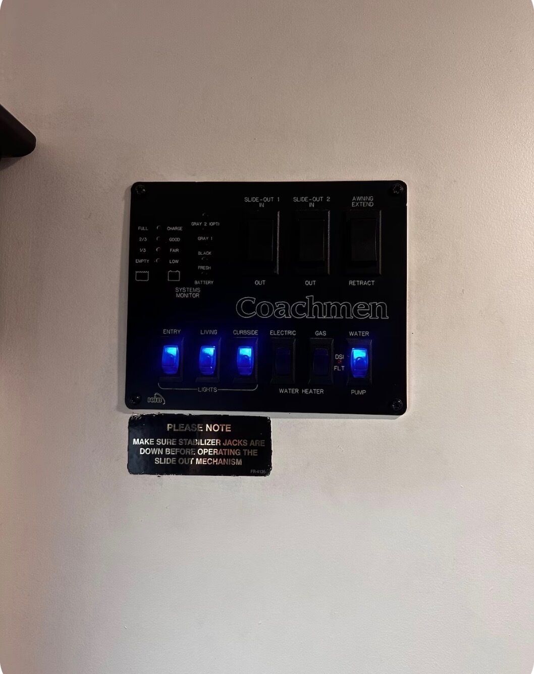 Een zwart elektronisch apparaat met meerdere knoppen en indicatoren, inclusief een waarschuwing over stabilisatorpoten.
