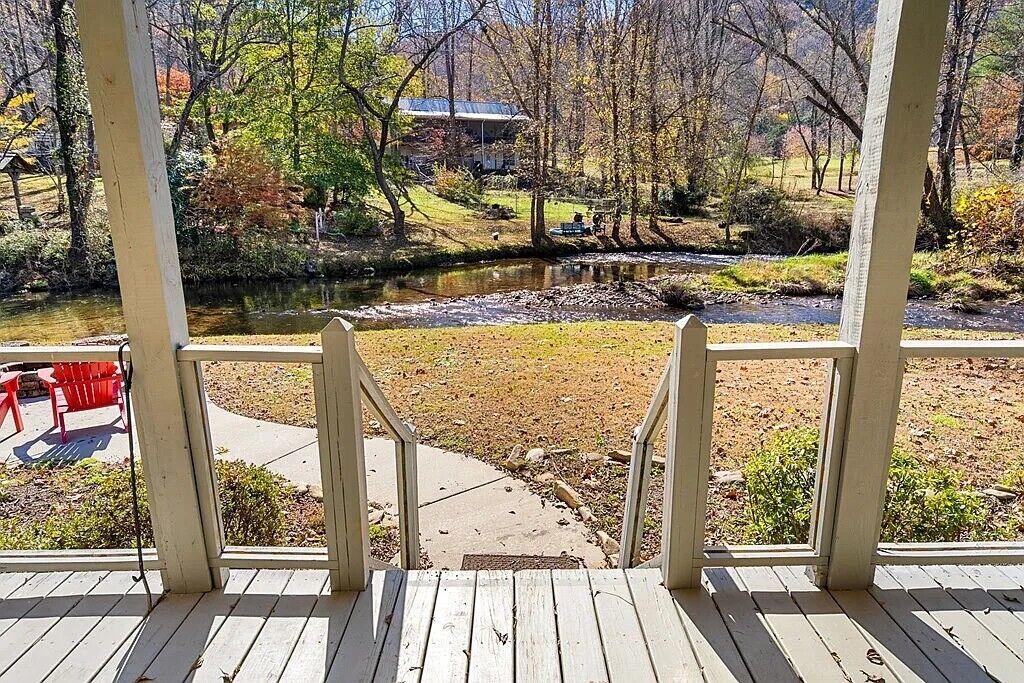 Une terrasse en bois offrant une vue sur une rivière et un bâtiment en arrière-plan.