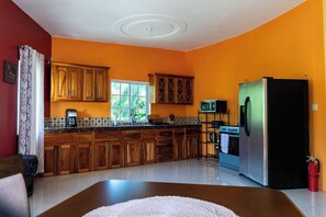 A kitchen with wooden cabinets, a refrigerator, and a microwave.