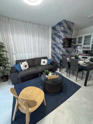 Ein modernes Wohnzimmer mit einer Couch, einem Couchtisch und einem Essbereich.