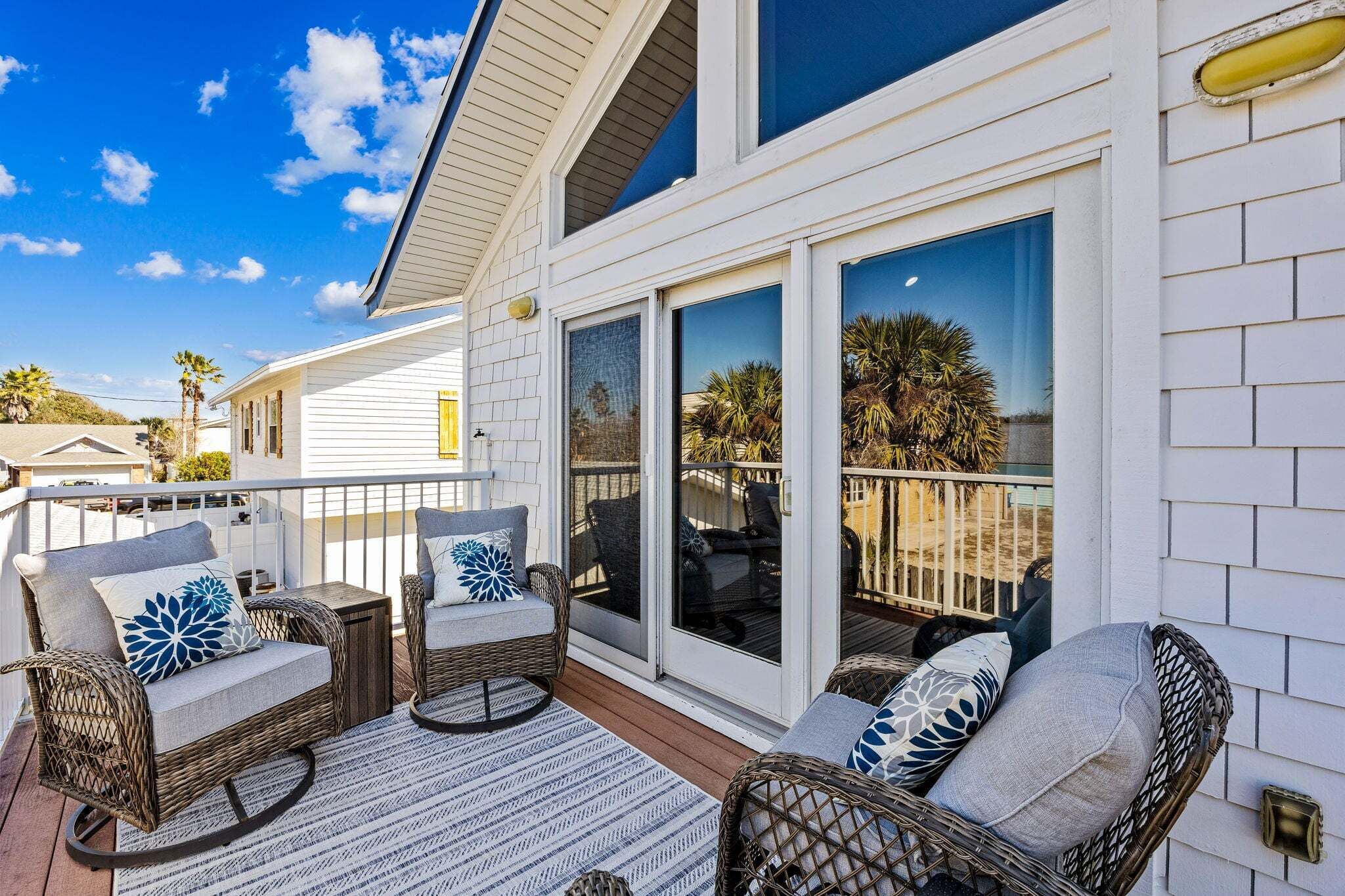 A covered patio area with wicker furniture and a view of the surrounding landscape.