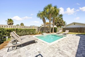 A backyard with a swimming pool, two lounge chairs, and a wooden fence. - Renovated and Spacious 6BR duplex on Amelia Island near the beach with pool (Fernandina Beach)