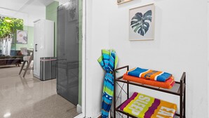 Ein Hotelzimmer mit Küchenzeile, einer Glastür, die auf einen Balkon führt, und einer Wand mit gerahmten Kunstwerken.