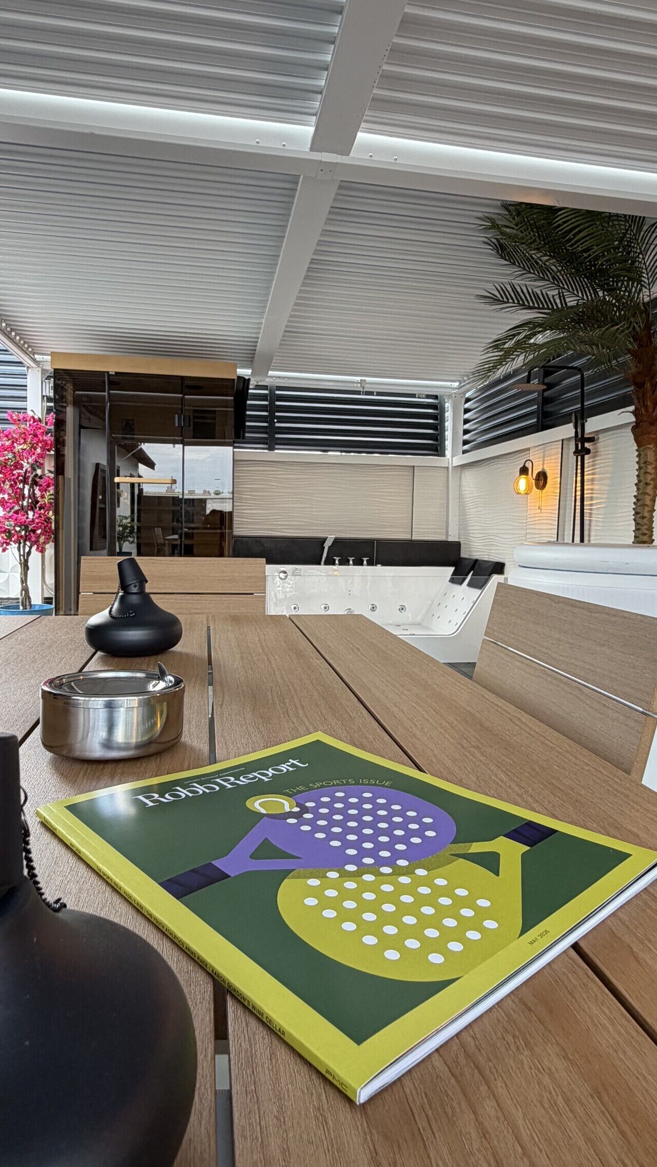 A modern outdoor seating area with a table, a magazine, and a decorative item.