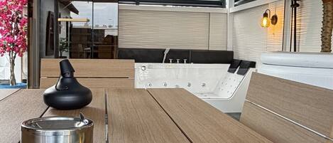 Un espacio exterior moderno con asientos, una mesa, una revista y un adorno decorativo.