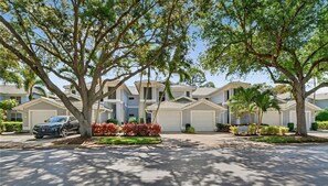 A residential area with multiple houses, a parked car, and well-maintained landscaping. - Luxury3BRNaplesCondo-Optional Club Membership- Beach Shuttle to Wiggins pass (Naples)