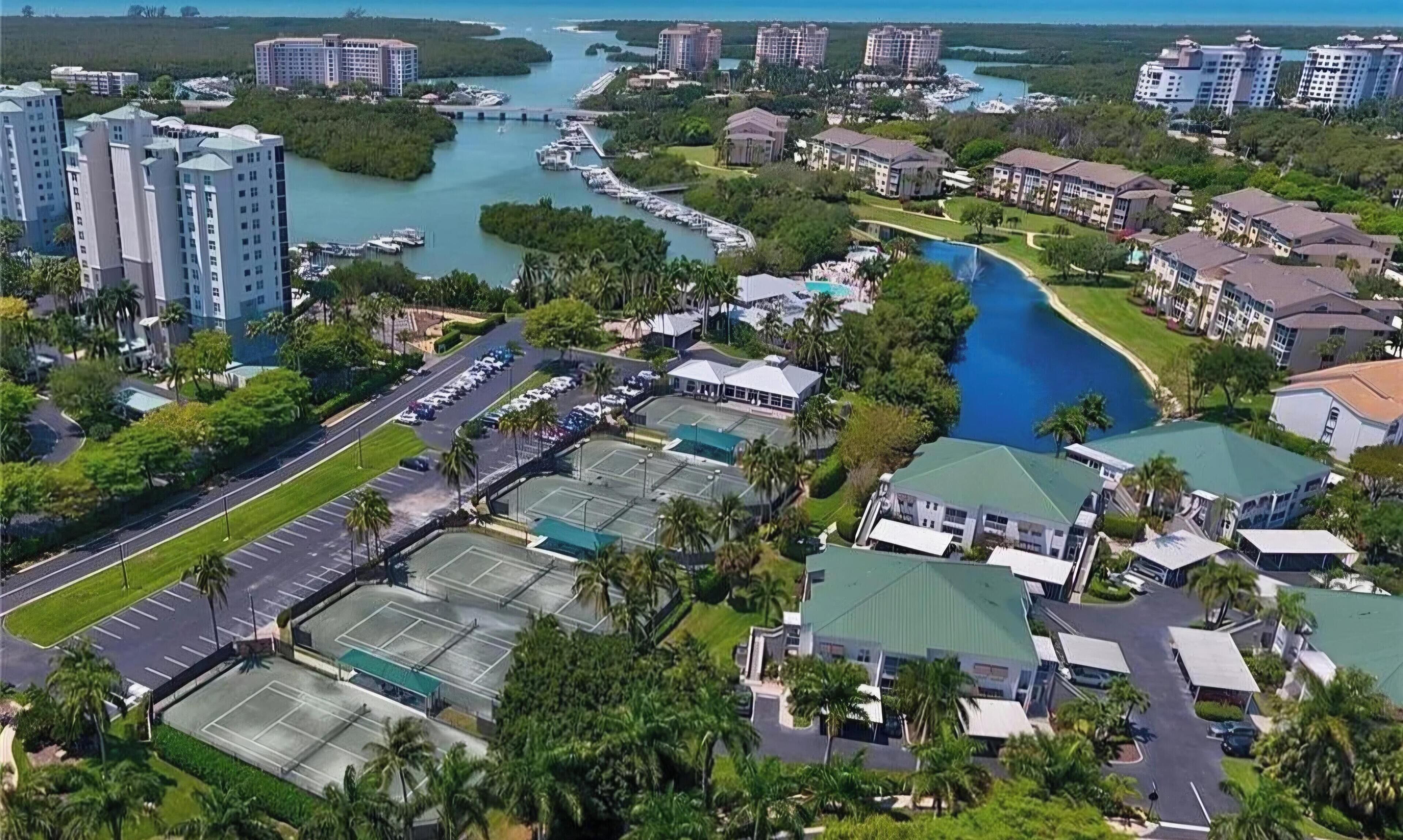 Un quartier résidentiel situé sur la côte, avec de nombreux immeubles de grande hauteur, une marina et une grande piscine.