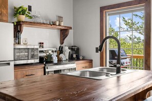 Eine Küche mit Holzarbeitsplatte, Edelstahl-Spüle und einer Kaffeemaschine.