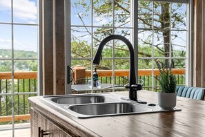 A kitchen with a stainless steel sink, a black faucet, and a wooden countertop. - Secluded Cabin_Lake Taneycomo View_Peaceful Deck_Bonus Loft_Free Attraction Tickets (Branson)