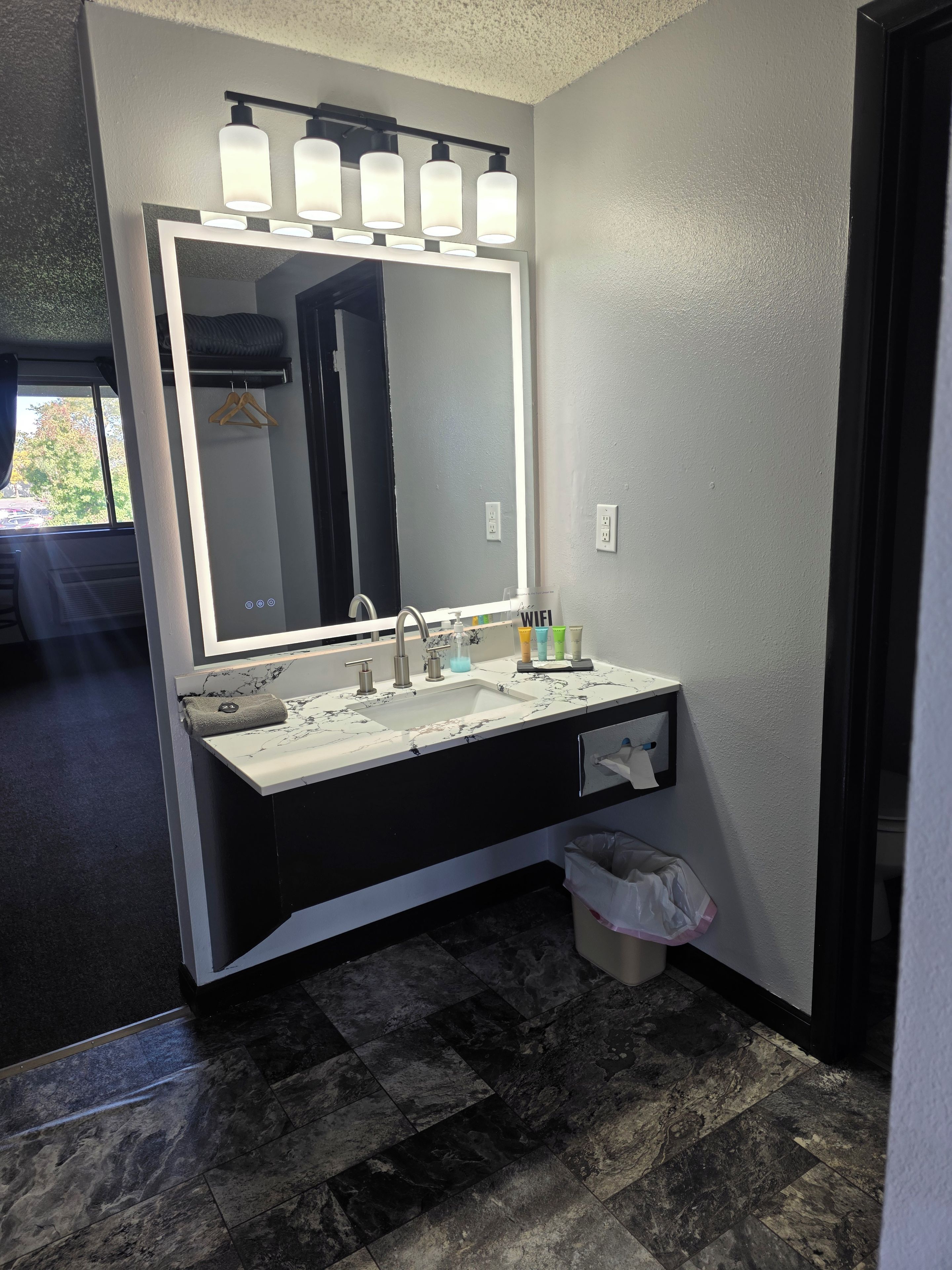 A modern bathroom with a large mirror, dual sinks, and a towel rack.