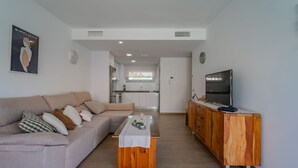 Un salon moderne avec un canapé, une table basse et un meuble pour la télévision.