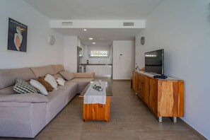 A modern living room with a sofa, coffee table, and TV stand. - Villa Amalia 9: Ground floor with garden (Torrevieja)