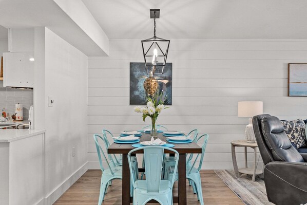 Comedor con una mesa de madera dispuesta para cuatro personas, rodeada por cuatro sillas.
