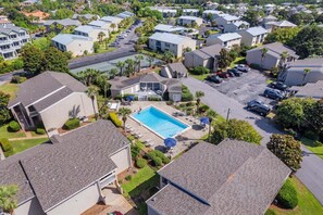 A residential area with a swimming pool surrounded by houses, a parking lot, and a clear sky. - CLM 16B  Gorgeous, pet friendly - Private beach access (Destin)
