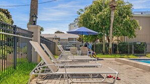 A poolside area with lounge chairs and a pool. - CLM 16B  Gorgeous, pet friendly - Private beach access (Destin)
