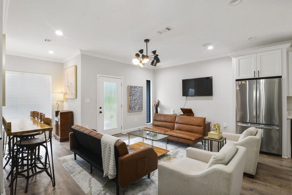 A modern living room with a sofa, coffee table, and dining area.