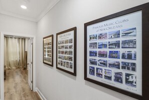 A hallway with framed pictures of New Orleans music clubs.