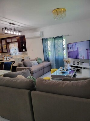 Ein modernes Wohnzimmer mit einer Couch, einem Couchtisch und einem Fernseher.