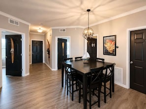 A dining area with a dark wooden table and chairs, a pendant light, and a framed picture on the wall. - Eagles Nest @ Lands End - Boat Slip! (Osage Beach)