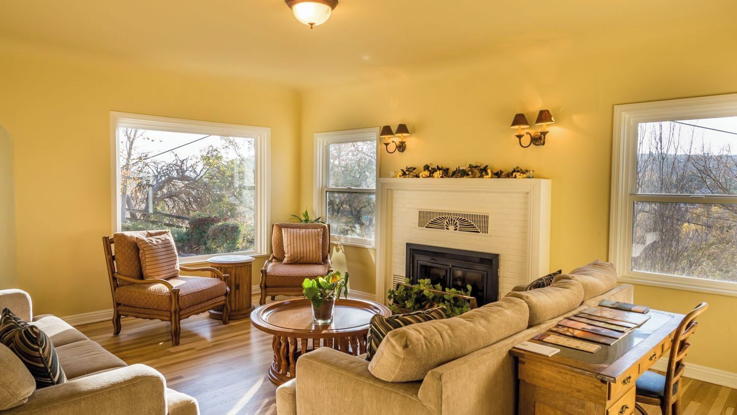 A living room with a fireplace, a sofa, a chair, a coffee table, and a bookshelf.