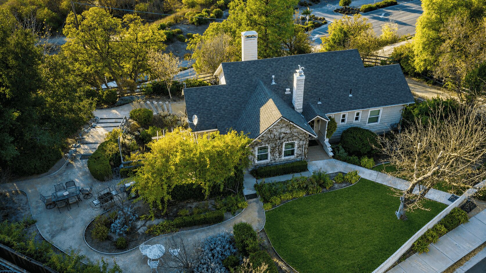A two-story house with a stone facade, a front yard, and a driveway.