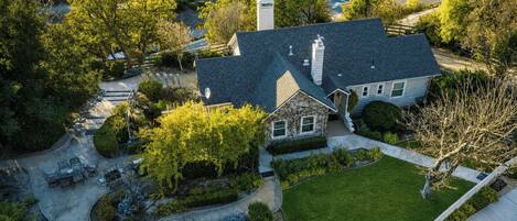 A two-story house with a stone facade, a front yard, and a driveway.
