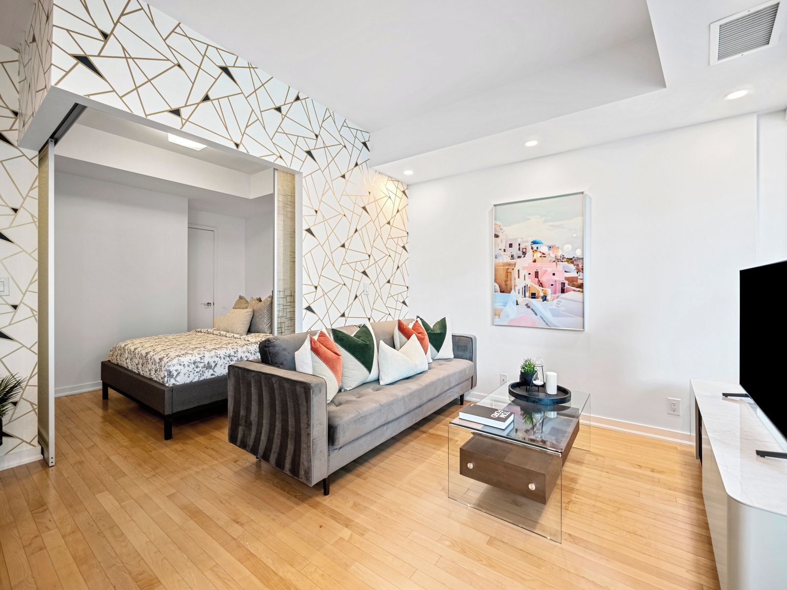 Un dormitorio moderno con cama, sofá y una mesita de centro.