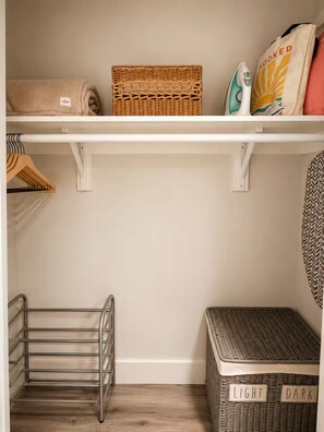 Ein Schrank mit Regalen, einer Kleiderstange und einem Metallgestell.