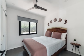A bedroom with a bed, a ceiling fan, a window, and decorative wall art. - Modern Villa | Private Pool | Near Playa Grande (Matapalo)