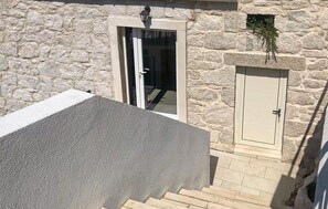 Ein Gebäude aus Stein mit einer Tür und einem kleinen Fenster.