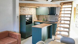 A compact kitchen with a stone wall, a built-in oven, and a wooden island with a sink. - Lovely home in Zaostrog with house sea view (Zaostrog)