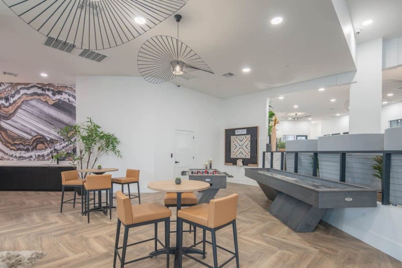 Un intérieur moderne avec un bar, des sièges et un grand tableau abstrait.