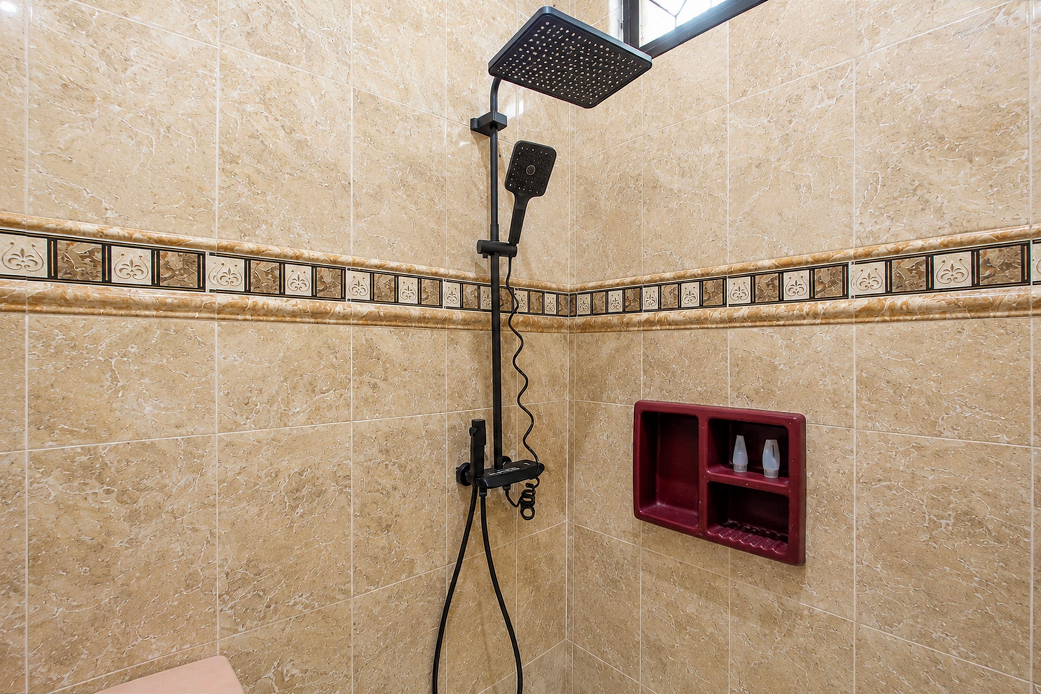 Un baño con ducha, tocador con espejo y un mueble de almacenamiento rojo.