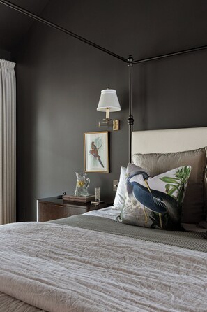 A bedroom with a bed, a nightstand, a lamp, a framed picture, and a pillow with a bird design. - Award Winning. East Austin. Pool. Speakeasy. 1 mi from DT. Events & photoshoots (Austin)