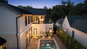 A two-story house with a swimming pool, outdoor lighting, and a balcony. - Award Winning. East Austin. Pool. Speakeasy. 1 mi from DT. Events & photoshoots (Austin)
