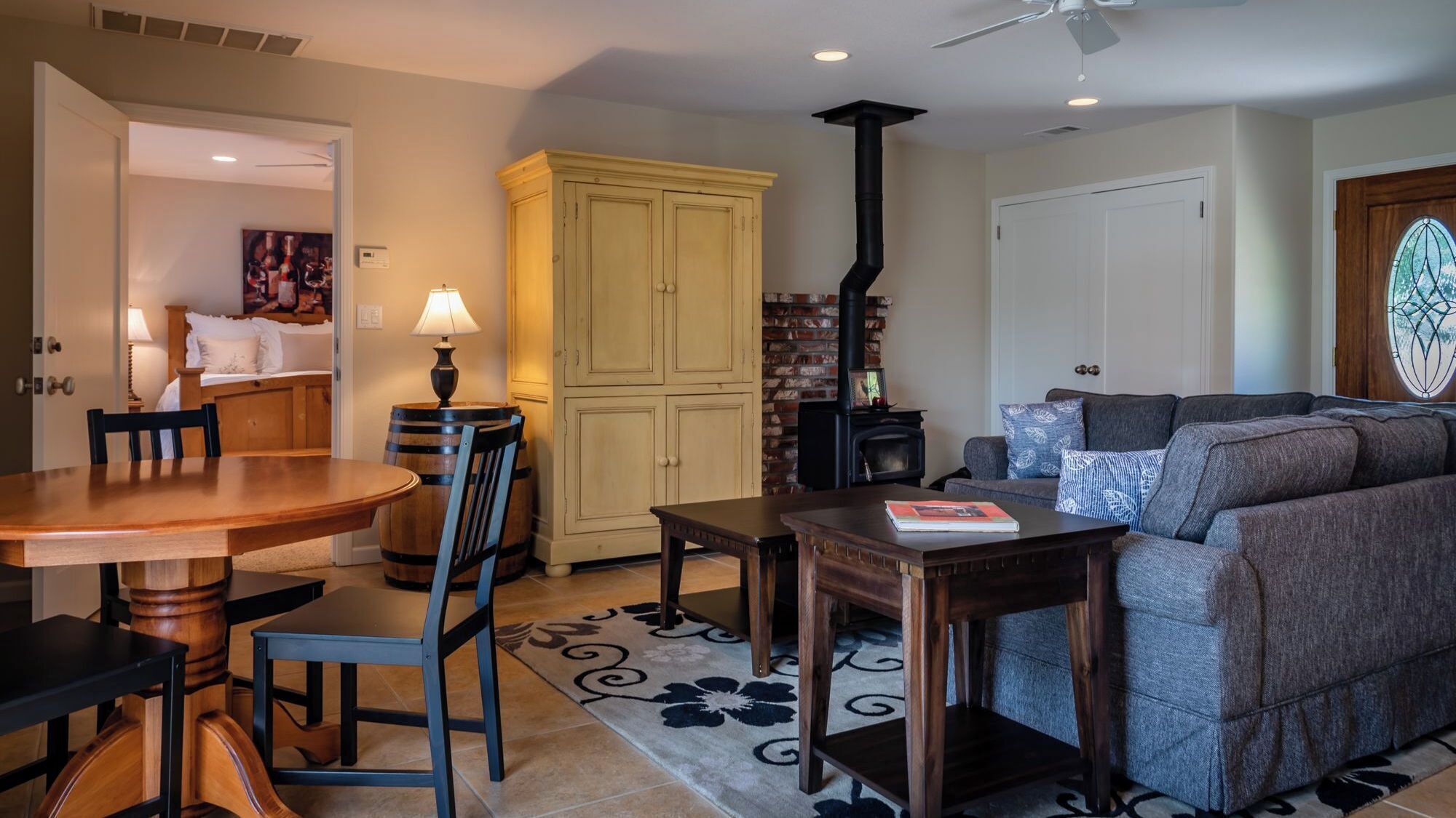 A living room with a fireplace, a sofa, a coffee table, and a dining area with a table and chairs.