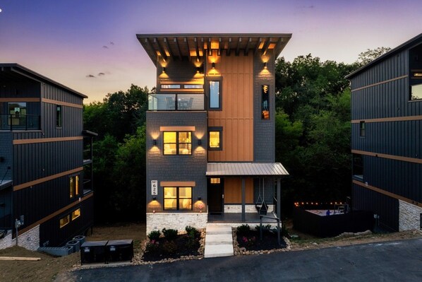 Un bâtiment moderne à plusieurs étages, doté d’un toit plat, de grandes fenêtres et d’une base en pierre.