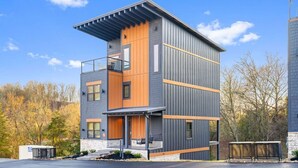 A modern two-story building with a flat roof, large windows, and a balcony. - CampingThemed/Pool/HotTub/GameRoom/FirePit/Sleep16 (Sevierville)