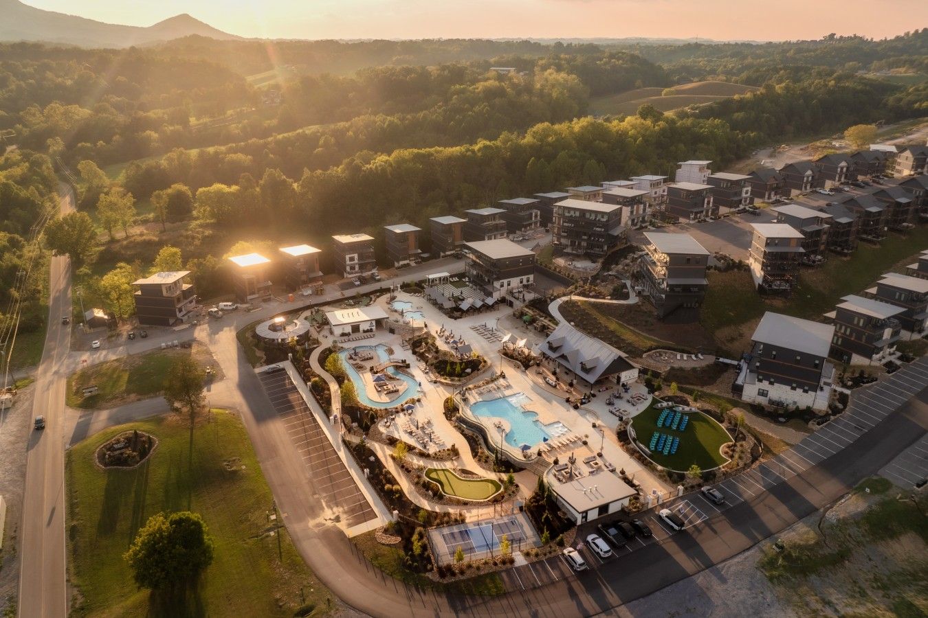 Vista aérea de un resort con varias edificaciones, piscina y zonas ajardinadas.