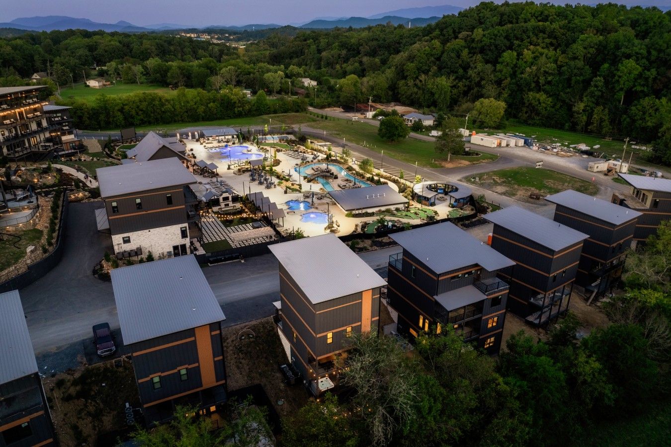 A resort with multiple buildings, a swimming pool, and a landscaped area.