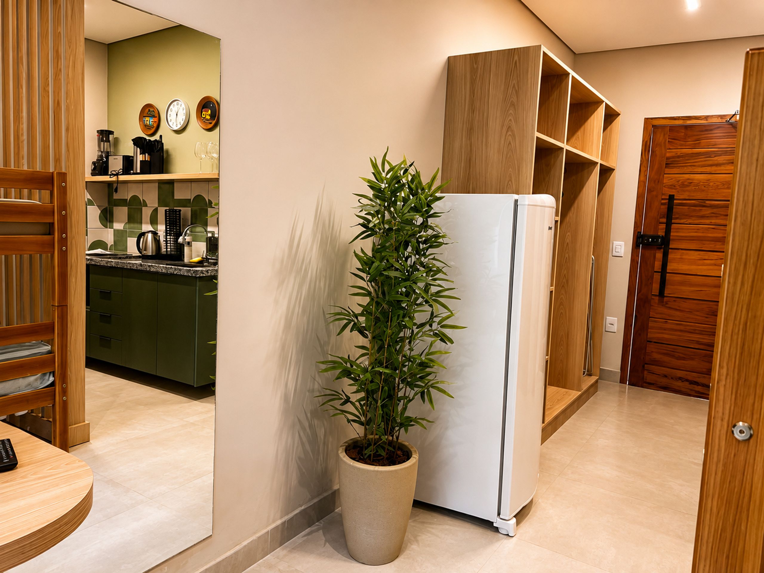 Una cocina moderna con refrigerador, planta en maceta y armarios de madera.